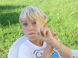 enfant blond montrant du doigt