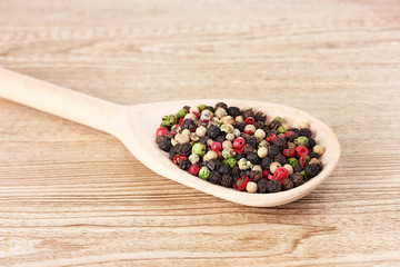 pepper spice on the spoon on wooden background