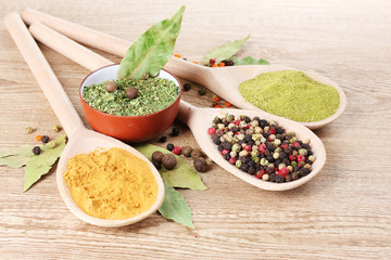 spices in the spoons on wooden background