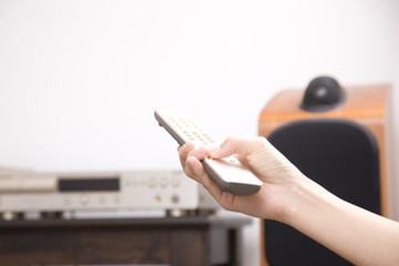 リモコンをもつ女性の手元