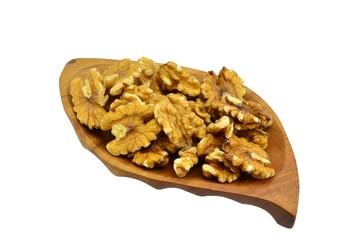 Walnuts on a leaf shaped wooden plate on white background