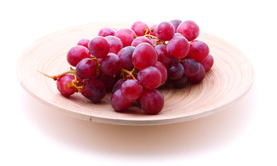 Image of red grape bunch in plate over white