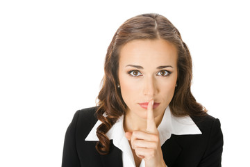 Serious businesswoman keeping finger on her lips, on white