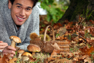 Man gathering mushrooms and chestnuts in the forest