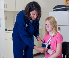 School nurse checking sling for broken arm
