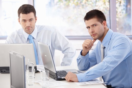 Young businessmen working at meeting table