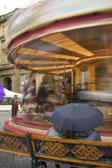 Women look at the carousel in Florence, Italy.