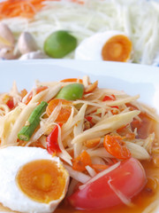 papaya salad with ingredients in the background