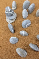 Fototapeta na wymiar alignement de galets sur le sable