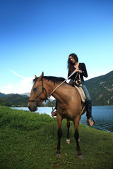 ragazza a cavallo in riva al lago in primavera