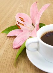 Cup of coffee and pink lily