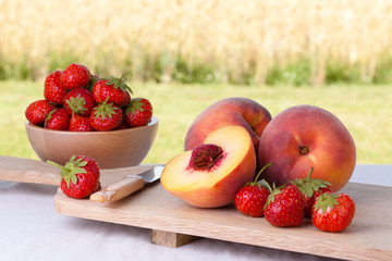Peaches and strawberries on a chopping board