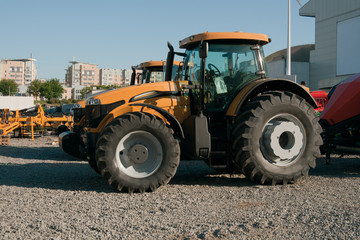 Wheelred modern yellow tractor on parking lot