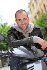 Obraz premium Portrait of young man sitting on motorcycle in town