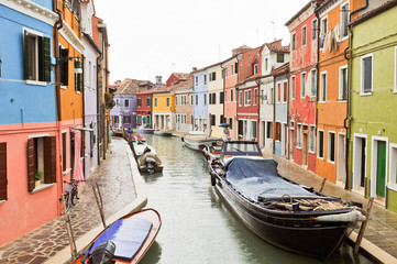 Fototapeta na wymiar Color houses and boats reflected in the water on Burano island, 