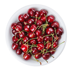 Obraz na płótnie Canvas Many red wet cherry fruits (berries) in round plate, isolated on
