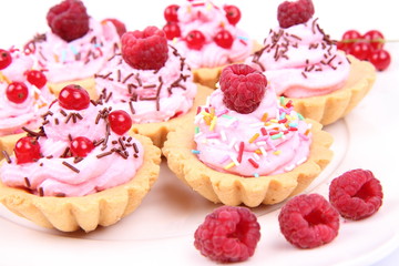 Tartlets with whipped cream, fruits and sprinkles
