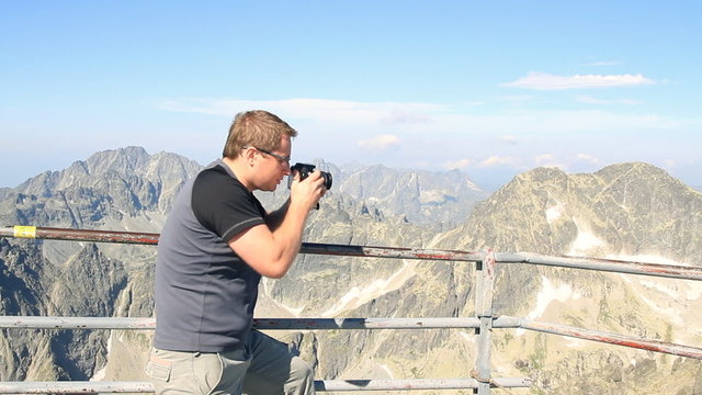 Man making photos in the mountains, steadicam shot