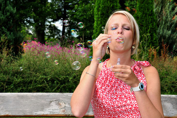 Young woman blowing soap bubbles