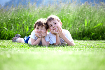 Fototapeta premium siblings lying on grass