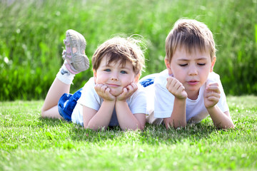 siblings lying on grass