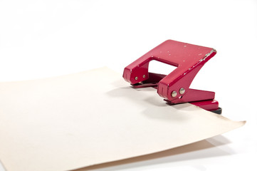 old hole punch with old paper on white background