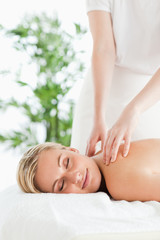 Good looking woman relaxing on a lounger during massage with clo