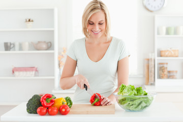Obraz na płótnie Canvas Smiling woman cutting vegetables