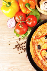 tasty pizza with olives and vegetables on a wooden background
