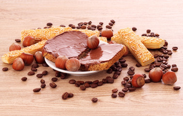 Bread, cookies and nuts with chocolate on wooden table