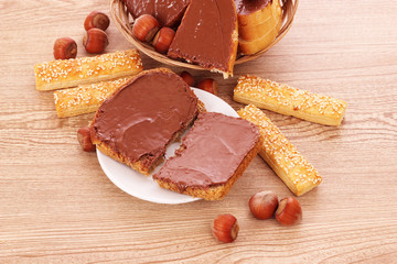 Bread, cookies and nuts with chocolate on wooden table