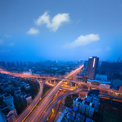 Freeway in night with cars light in modern city.