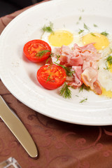 fried eggs with bacon and vegetables