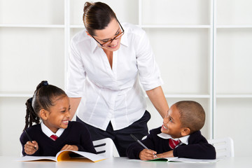 Fototapeta premium elementary teacher talking to pupils in classroom