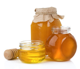 glass jar and pot of honey with stick