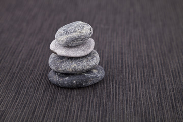 Fototapeta na wymiar Pile of pebbles, on a grey cotton background