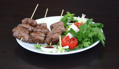 Portion of meatballs served with salad inegol kofte