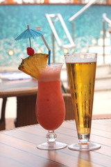 glass of fruit cocktail and a glass of beer
