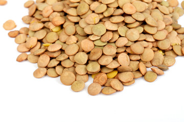 Pile of green lentils from low perspective isolated on white.
