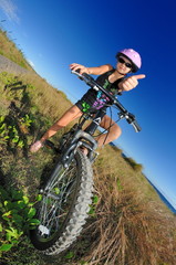 Obraz na płótnie Canvas Dziewczyna z roweru są w trawie.