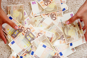 Hände greifen in einen Haufen von Geld