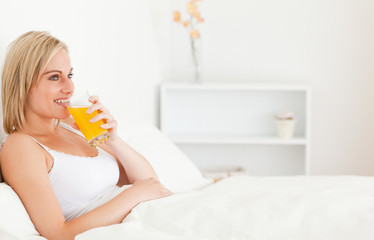 Obraz na płótnie Canvas Blonde woman drinking juice