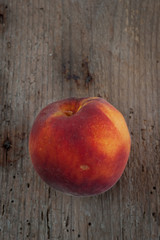Organic peach on an old wooden board