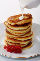 Pancakes with sour cream sauce and red currants.