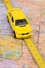 Toy car and steel tape on map