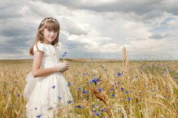girl wearing first communion dress between barley