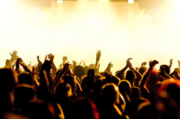 concert crowd in front of bright yellow stage lights