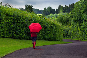 Woman with red umbrella on an overcast day.