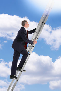 Businessman Climbing A Ladder In The Sky