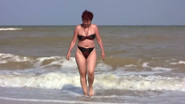 женщина выходит из моря